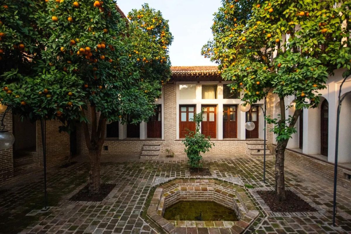 حیاط سنتی بوتیک هتل هفتپیکر گرگان با معماری آجری و درختان نارنج