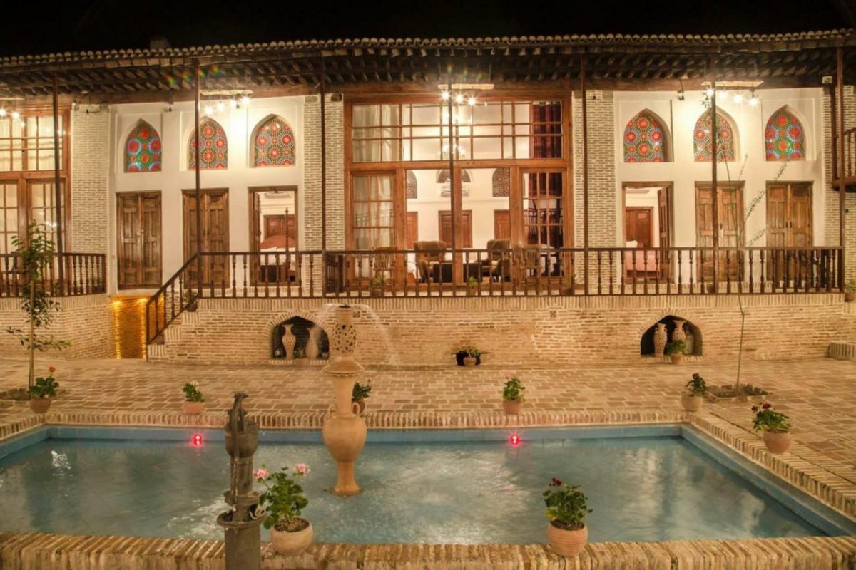 حیاط بوتیک هتل سرای خان گرگان با حوض آب و پنجرههای رنگی سنتی